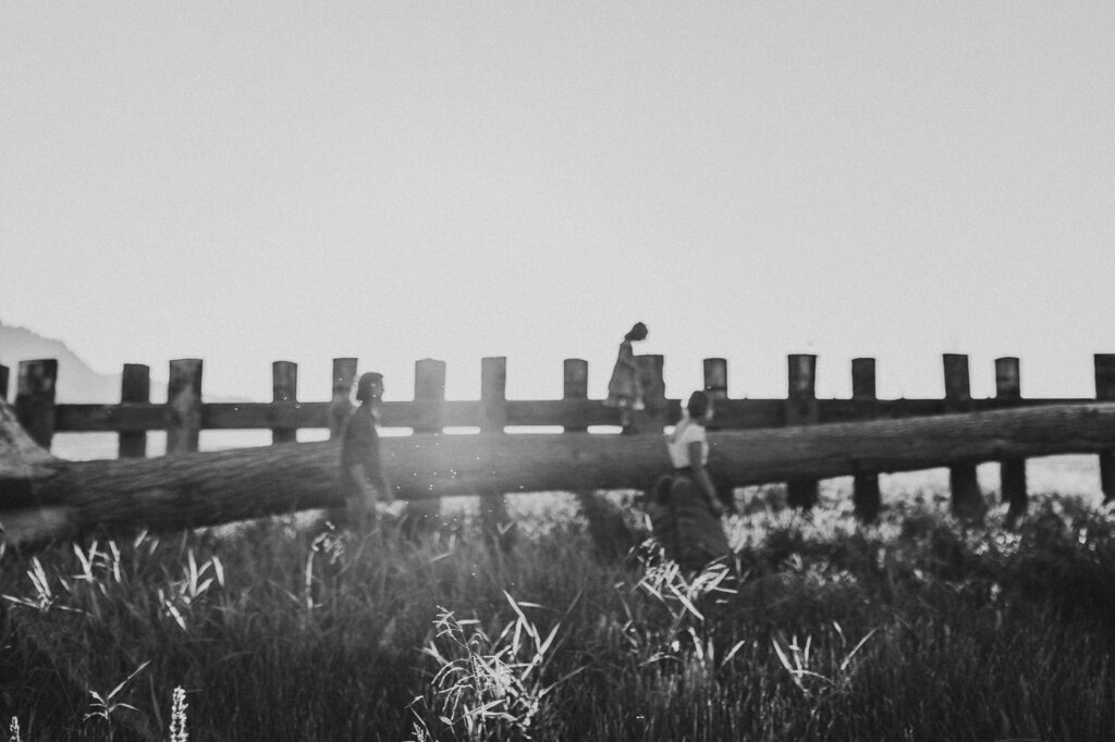 Black and white candid photo of a family with young kids walking together outdoors.