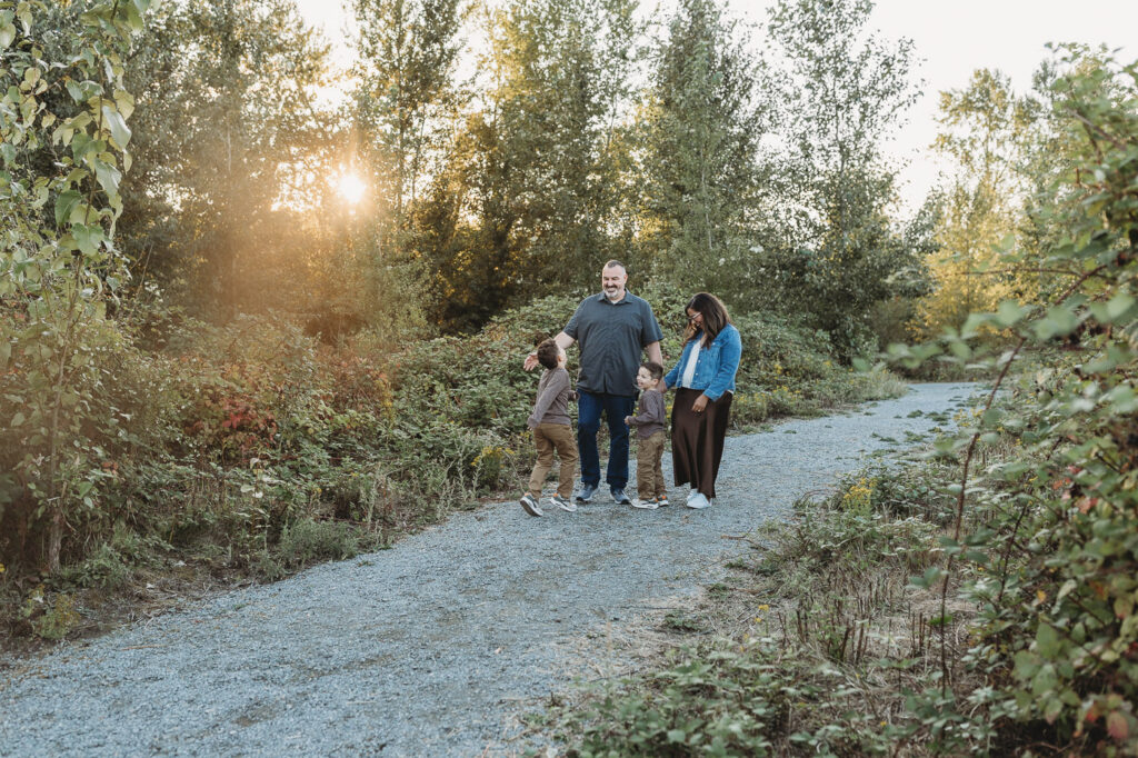 Family photos with young kids walking together outdoors during a candid family session.